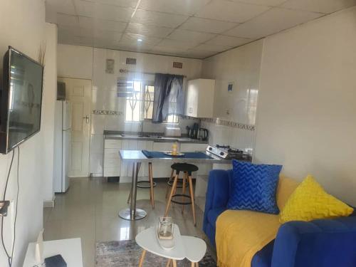 KitweBlueView Apartments的一间带蓝色沙发的客厅和一间厨房