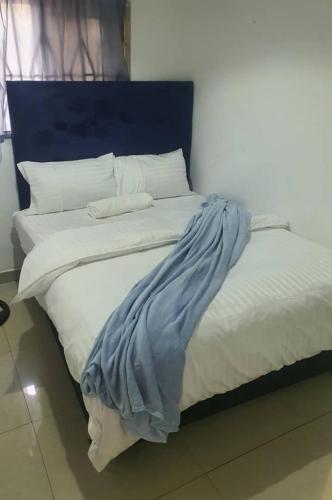 KitweBlueView Apartments的一张带蓝色床头板、白色床单和枕头的床