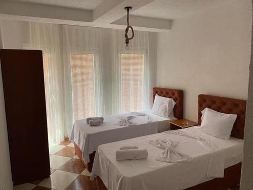 斯特鲁加Hotel Montenegro的一间卧室配有两张床、白色床单和窗户。