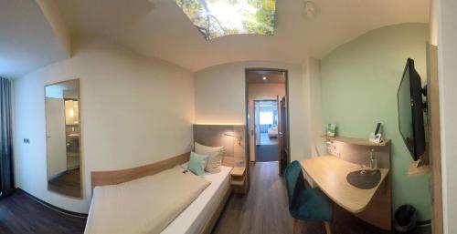 帕德博恩IN VIA Hotel的一间小卧室,配有一张床和镜子