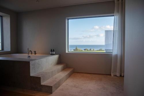 锡姆里斯港Hotel Vyn的带浴缸的浴室和大窗户