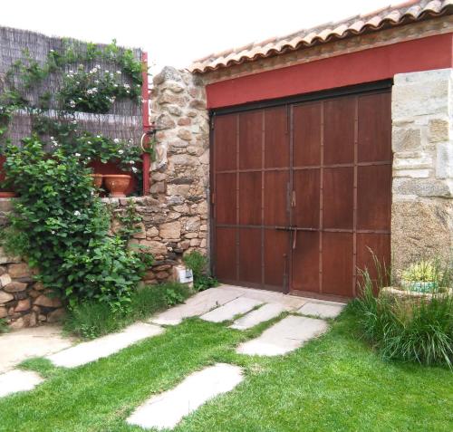 PlasenzuelaCASA GIBRANZOS的木车库门,带有石墙