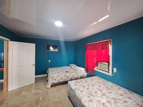 埃尔莱马特Apartamento La Estrella的配有两张床铺的蓝色墙壁和窗户