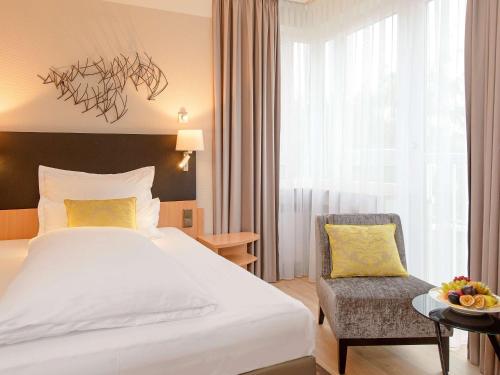 科隆美居科隆贝佛斯特拉瑟酒店的配有一张床和一把椅子的酒店客房