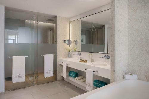 阿德耶Royal Hideaway Corales Suites的带浴缸、水槽和镜子的浴室