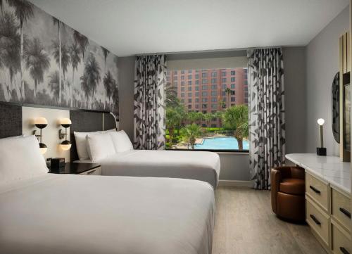 奥兰多Caribe Royale Orlando的酒店客房设有两张床和窗户。