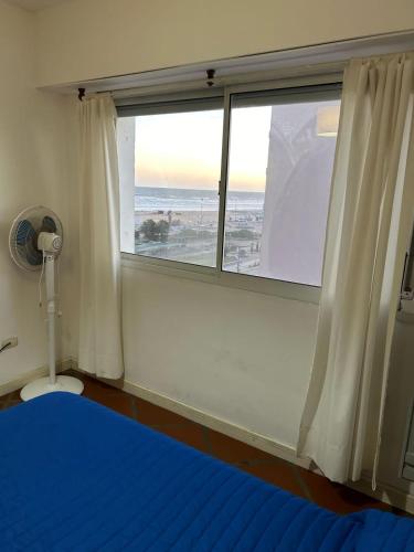 内科切阿Marítima mono ambiente的一间卧室设有窗户,配有蓝色的床和蓝色