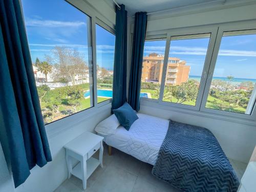 马拉加Apartamento con vistas al mar a 1 min de la playa的一间卧室设有一张床和美景窗户。