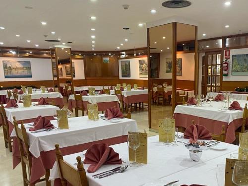 圣胡利娅-德洛里亚佛知酒店的一间设有白色桌子和红色餐巾的用餐室