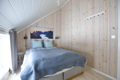 巴尔斯塔Cabin in Lofoten with spectacular view的卧室配有一张床铺,位于带木墙的房间内