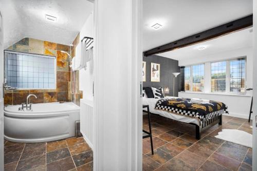 基德明斯特Luxury Spacious Retreat with Hot Tub & Massage beds的带浴缸、床和浴缸的浴室