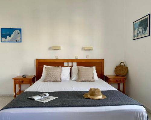 纳克索乔拉Ammosis Inn的一间卧室,配有一张床,上面有帽子