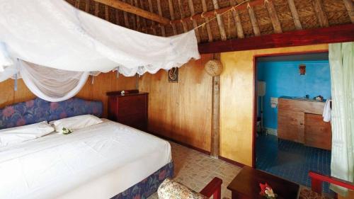 Nanuya LailaiGold Coast Inn - Adults Only的一间带白色床的卧室和一间厨房
