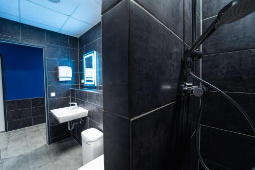 柏林Space Night Capsule Hostel的浴室配有卫生间、盥洗盆和淋浴。