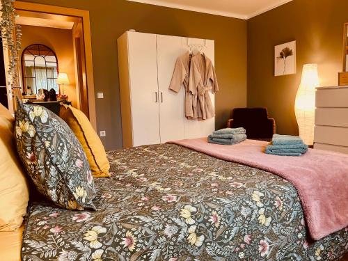 卢森堡Guest House的一间卧室,配有一张挂在衣柜上的带外套的床