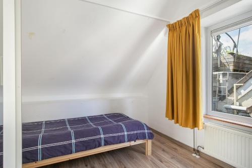 斯希丹Tourist Travel Inn的一间卧室设有一张床和一个窗口