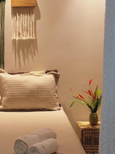 普拉杜Quarto vista mar的一间卧室配有一张带枕头和植物的床