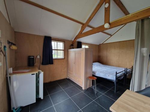 De ValomBlokhut camping De Zilveren Maan的一间小房间,房子里设有一张小床