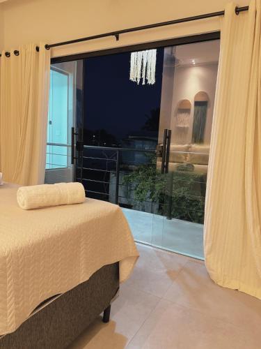 普拉杜Quarto vista mar的一间卧室设有一张床和一个大窗户