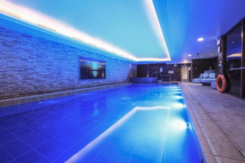 基督城Harbour Hotel & Spa Christchurch的蓝色灯光的酒店游泳池