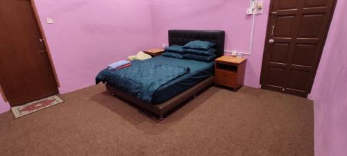 巴西富地Homestay Azihan的紫色客房内的一间卧室,配有一张床