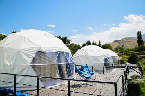 罕萨SG Glamping Resort的两顶圆顶帐篷 - 带蓝色椅子的甲板