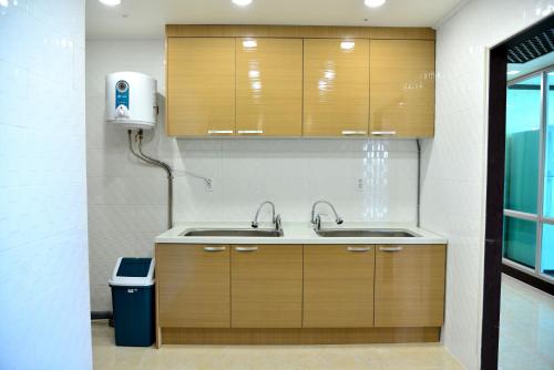 西归浦市Seom Guesthouse的厨房配有两个水槽和垃圾桶