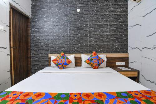 SāntrāgāchiFabExpress Subh Residency的一间卧室配有带色彩缤纷枕头的床