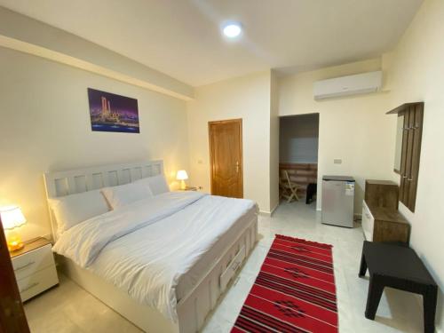 瓦迪穆萨Petra rose city的卧室配有一张白色大床和红色地毯。