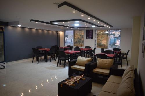 瓦迪穆萨Petra rose city的餐厅设有桌子、沙发和桌椅