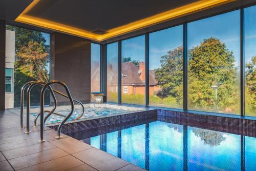 吉尔福德Harbour Hotel & Spa Guildford的房屋内一个带两把椅子的游泳池