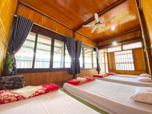北市Duy Tuyen Ba Be Homestay Free BBQ的客房设有四张床和吊扇。