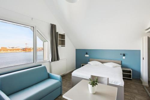 敦刻尔克All Suites Appart Hôtel Dunkerque的酒店客房设有床、沙发和窗户。