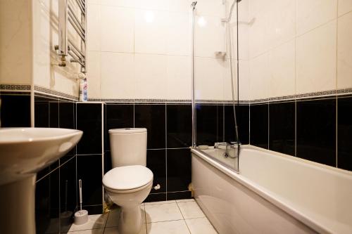 凯特林Eagle homely apartment的浴室配有卫生间、浴缸和水槽。