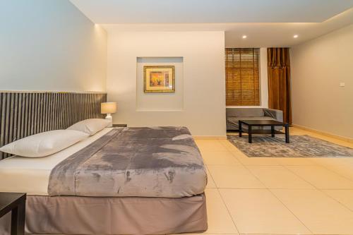 拉斯阿尔卡麦人达累斯萨拉姆公寓式酒店的一间卧室配有一张大床和一张书桌