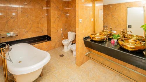 拉斯阿尔卡麦人达累斯萨拉姆公寓式酒店的一间带水槽和两面镜子的浴室以及一间卫生间
