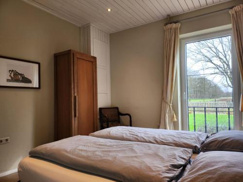 海尔翠森Landhuis de heibloem的一间卧室设有两张床和窗户。