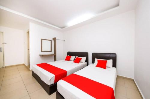 马六甲Nexus Hotel的配有2张床铺的白色和红色床单