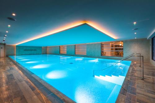 泰晤士河畔里士满Harbour Hotel & Spa Richmond的一座拥有蓝色灯光的大型游泳池