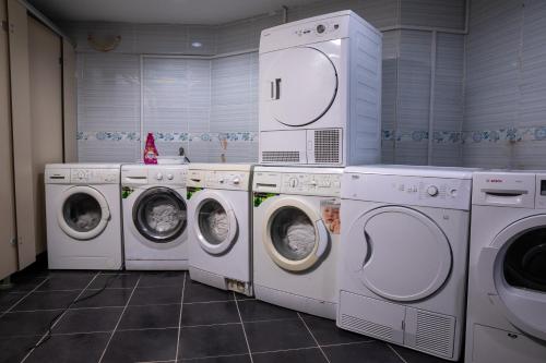 伊斯坦布尔Studio in a social environment的洗衣房配有3台洗衣机和干衣机