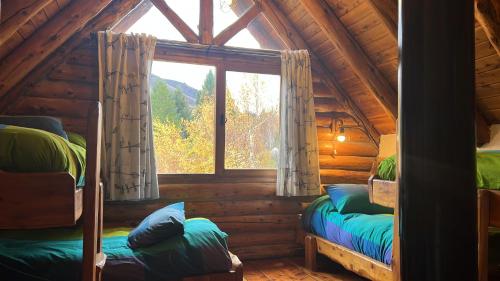 圣卡洛斯-德巴里洛切Los Nires Lodge Cerro Catedral的小木屋内一间卧室配有两张双层床
