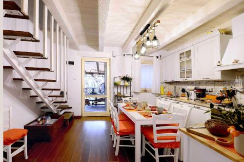 安科纳Lillac Cottage的一间带桌椅和楼梯的厨房