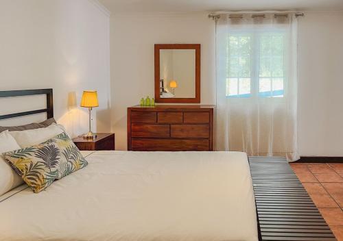 拉戈阿WelcomeBuddy - Casa Tia Néné - Green Glassyard的一间卧室配有一张床、梳妆台和镜子
