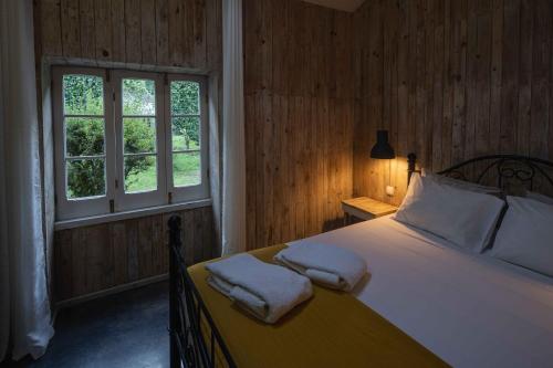 富尔纳斯WelcomeBuddy - Quinta D'Água的一间卧室配有一张床,上面有两条毛巾