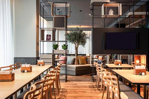 帕德博恩IntercityHotel Paderborn的餐厅设有桌椅和沙发。