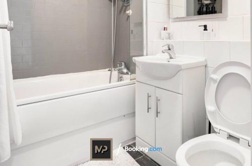 埃普瑟姆Luxury Apartment By Mechanical Properties Short Lets and Serviced Accommodation Epsom with Parking的白色的浴室设有卫生间、浴缸和水槽。
