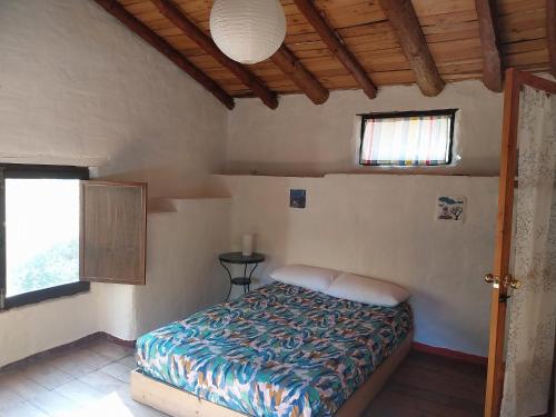 科迪加纳富希奥德米洛斯乡村民宿的一间带床的卧室,位于带窗户的房间内