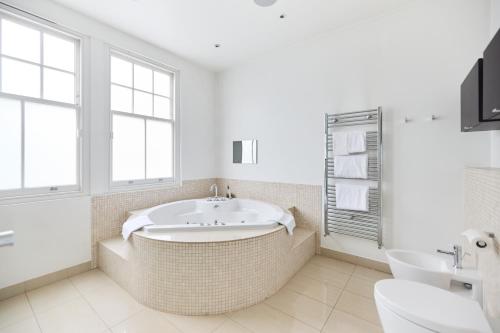 伦敦The Clapham Crib - Spacious 4BDR House with Patio的一间带大浴缸和水槽的浴室