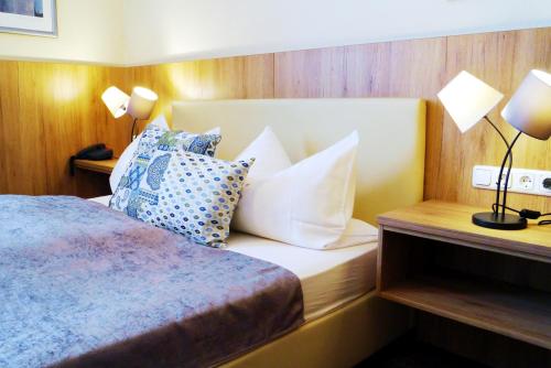 瓦尔德纳布河畔诺伊施塔特格拉德酒店的酒店客房配有带枕头和灯具的床。