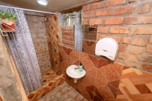 卡哈马卡Cabaña Kinti Yuraq en Kinti Wasi的一间带水槽和砖墙的浴室